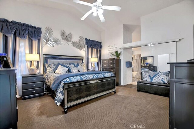 bedroom with ceiling fan, dark carpet, and vaulted ceiling