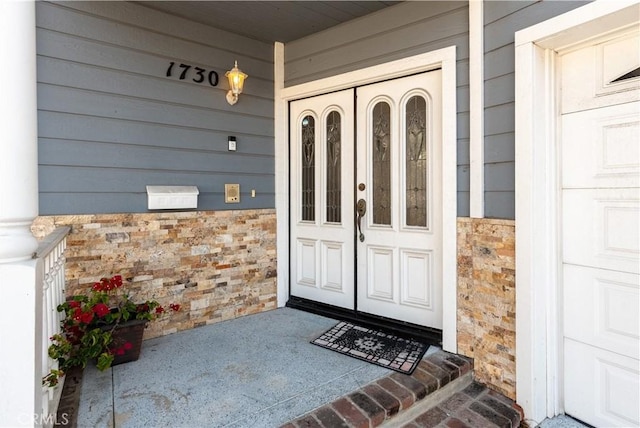 view of exterior entry featuring covered porch