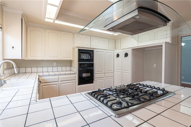 kitchen featuring sink, tile counters, and black appliances