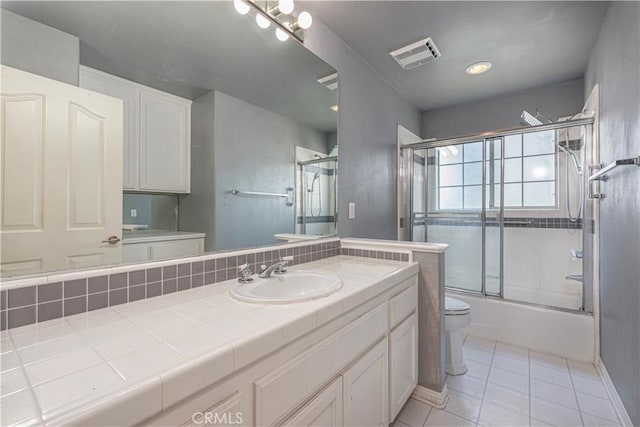 full bathroom featuring tile patterned floors, vanity, bath / shower combo with glass door, and toilet