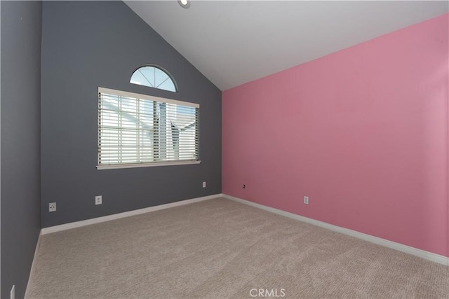 spare room with light colored carpet and high vaulted ceiling