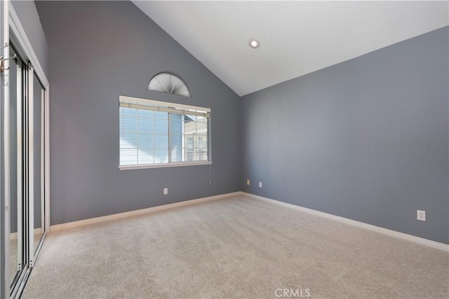 unfurnished bedroom with light carpet, high vaulted ceiling, and a closet