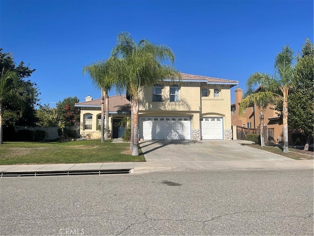 mediterranean / spanish-style home with a front lawn and a garage