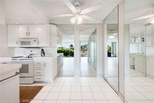 kitchen featuring tasteful backsplash, white appliances, ceiling fan, white cabinets, and light tile patterned flooring