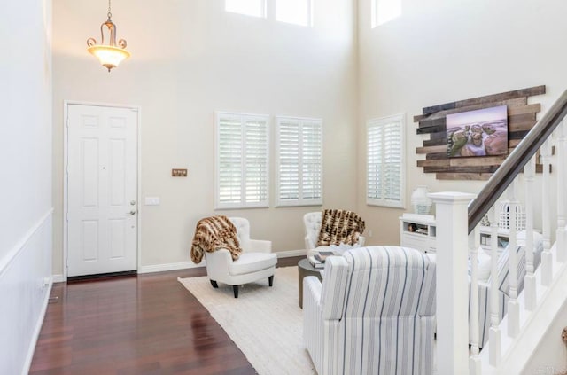 living area featuring a high ceiling and dark hardwood / wood-style floors