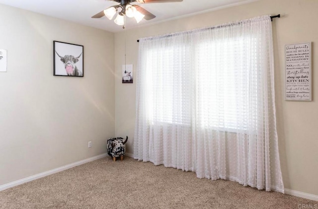 carpeted spare room with ceiling fan