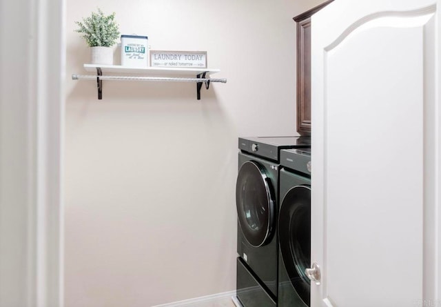 clothes washing area featuring cabinets and washing machine and dryer