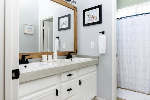 bathroom featuring walk in shower and vanity