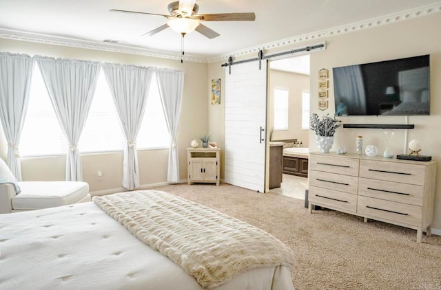 bedroom with a barn door, connected bathroom, light carpet, and ceiling fan