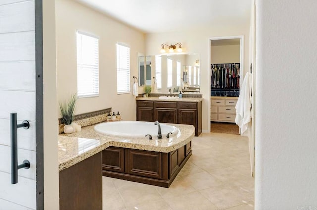 bathroom featuring vanity, tile patterned flooring, and a bath