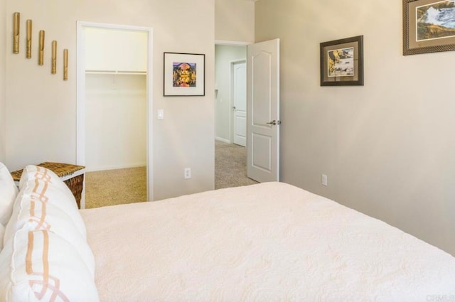 carpeted bedroom with a closet and a walk in closet