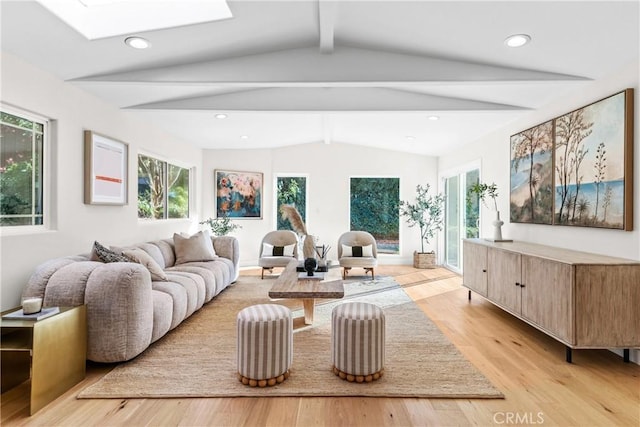 living area with recessed lighting, vaulted ceiling with skylight, and light wood finished floors