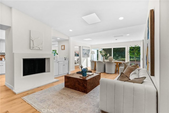 living room with a skylight and light hardwood / wood-style floors