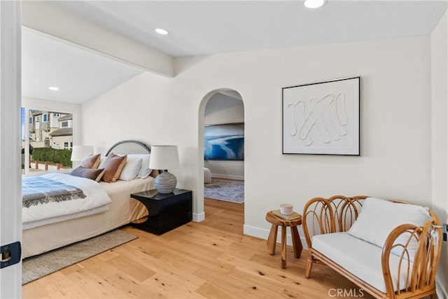 bedroom featuring wood-type flooring and vaulted ceiling with beams