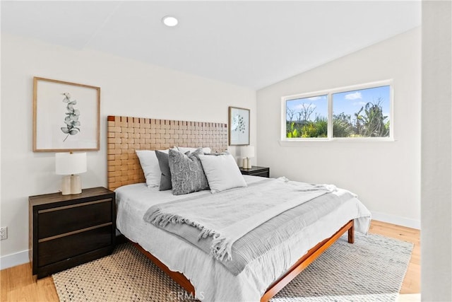 bedroom featuring hardwood / wood-style flooring and lofted ceiling