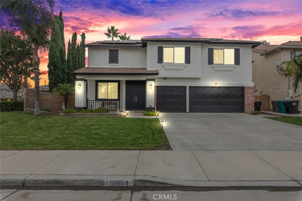 front of property featuring a lawn and a garage