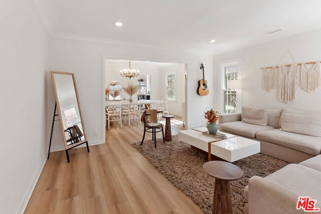 living room with light hardwood / wood-style flooring and a chandelier