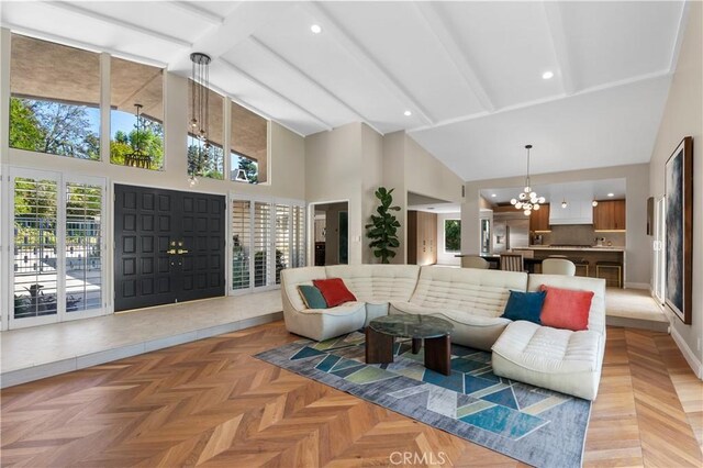 living room featuring light parquet floors, a high ceiling, and a notable chandelier