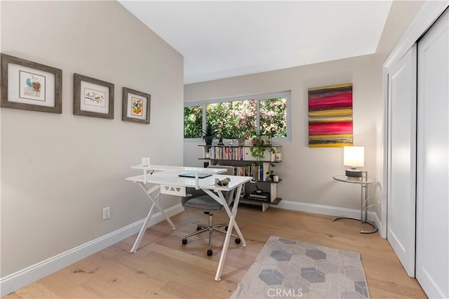 home office featuring light wood-type flooring and baseboards