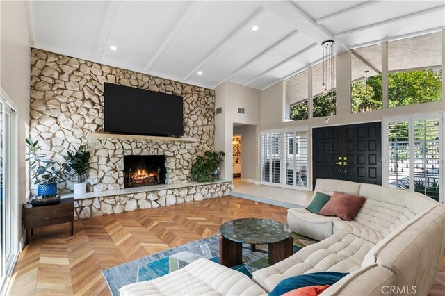 living room featuring beam ceiling, a stone fireplace, parquet flooring, and high vaulted ceiling