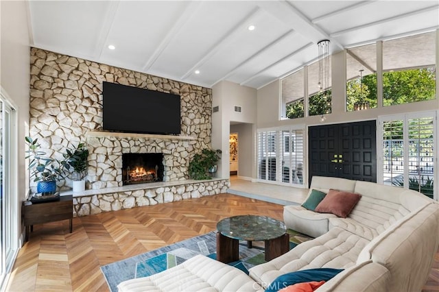 living room with parquet floors, a fireplace, high vaulted ceiling, and beamed ceiling