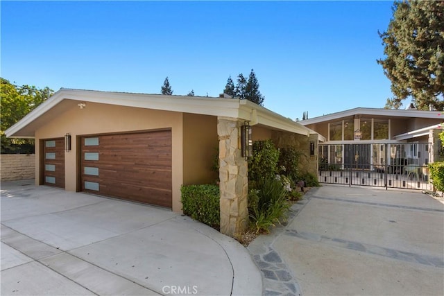 view of front of house featuring fence, a garage, and stucco siding