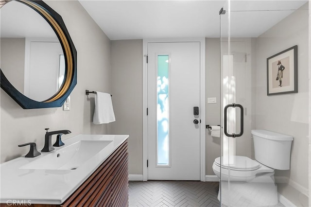 bathroom featuring vanity, toilet, and baseboards