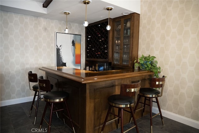 bar featuring pendant lighting, a dry bar, wallpapered walls, and baseboards