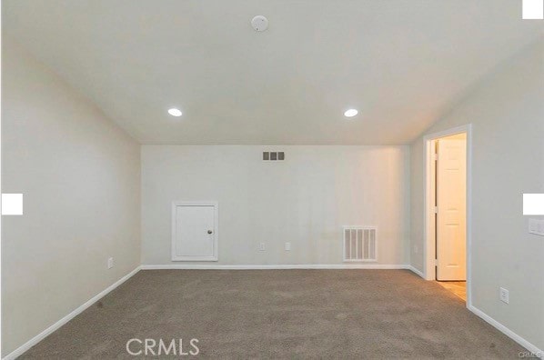 carpeted spare room with vaulted ceiling