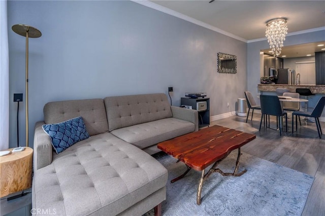 living room featuring hardwood / wood-style flooring, ornamental molding, and a chandelier