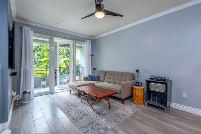 living room with wood-type flooring, ceiling fan, and crown molding