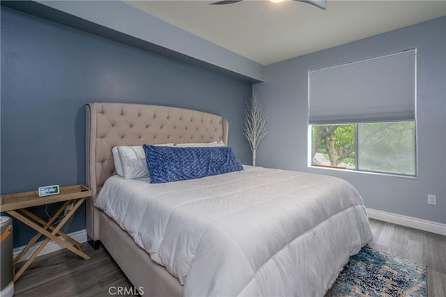 bedroom with dark hardwood / wood-style flooring and ceiling fan