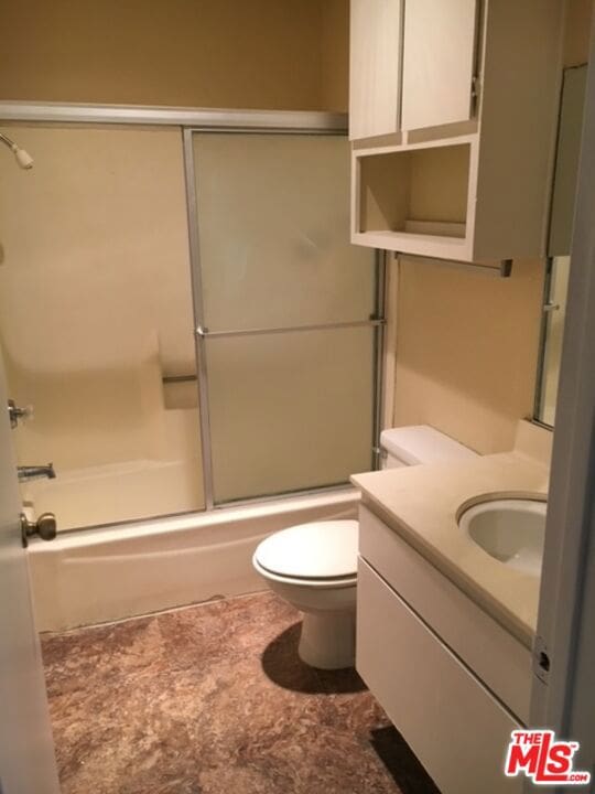 full bathroom featuring shower / bath combination with glass door, vanity, and toilet