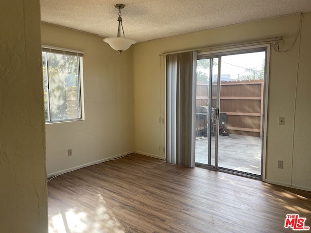 unfurnished room featuring hardwood / wood-style flooring and a textured ceiling