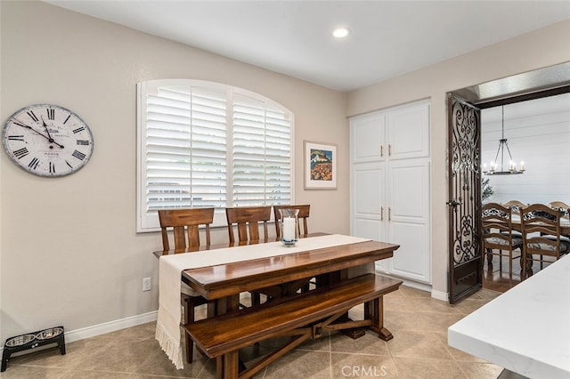 tiled dining area featuring an inviting chandelier