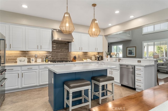 kitchen featuring dishwasher, a center island, exhaust hood, and a kitchen breakfast bar