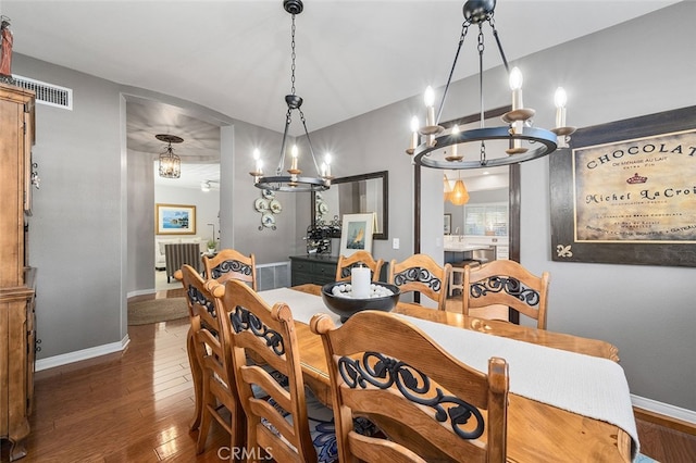 dining space featuring a notable chandelier and dark hardwood / wood-style flooring