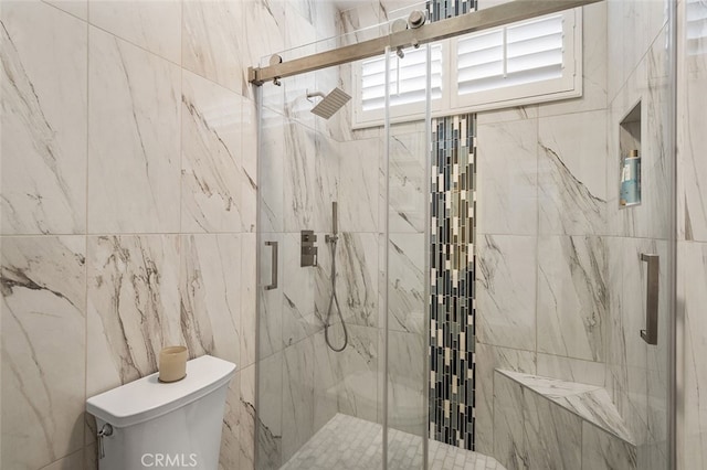 bathroom featuring toilet and a shower with door