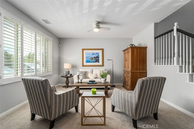 living area featuring ceiling fan and light colored carpet