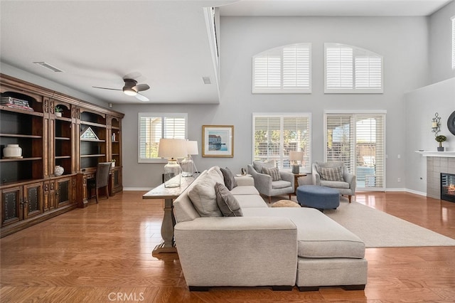 living room with ceiling fan, a fireplace, hardwood / wood-style floors, and a wealth of natural light