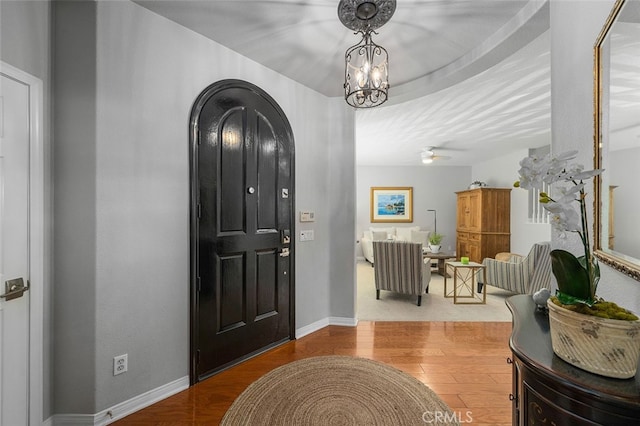 entrance foyer with wood-type flooring and ceiling fan with notable chandelier