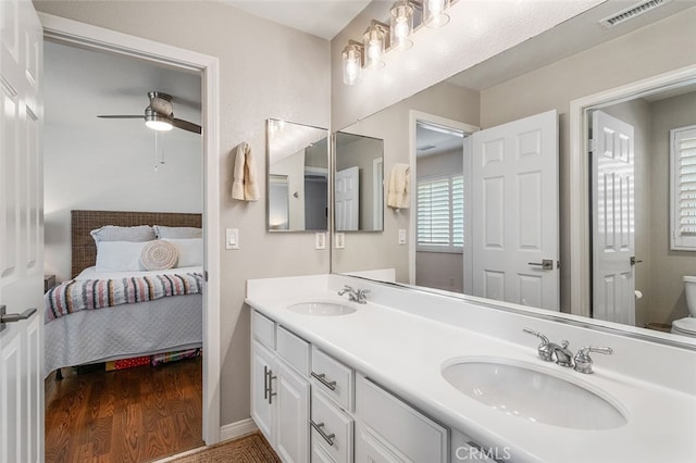 bathroom with ceiling fan, vanity, toilet, and wood-type flooring