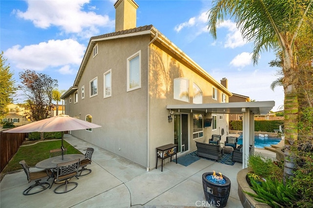 rear view of property with outdoor lounge area, a fenced in pool, and a patio area