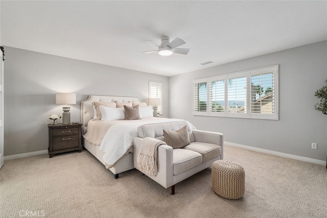 carpeted bedroom featuring multiple windows and ceiling fan