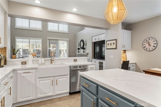 kitchen with light stone counters, sink, stainless steel dishwasher, and white cabinetry