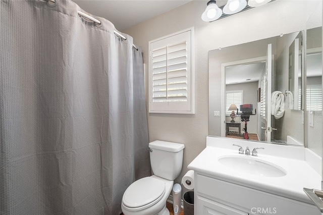 bathroom with vanity, toilet, and curtained shower