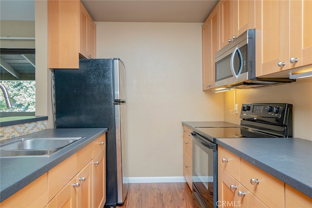 kitchen featuring light brown cabinets, sink, appliances with stainless steel finishes, and light hardwood / wood-style floors