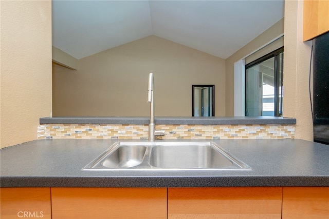 kitchen with lofted ceiling, tasteful backsplash, and sink