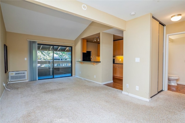 unfurnished living room featuring light hardwood / wood-style floors, vaulted ceiling, and a wall mounted AC