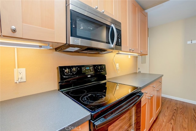 kitchen featuring light brown cabinetry, black electric range, and light hardwood / wood-style floors